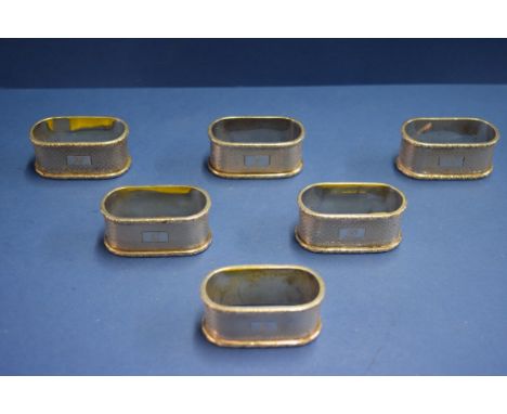 A set of six engine turned silver napkin rings, by Crisford & Norris Ltd, Birmingham 1950, 193g.