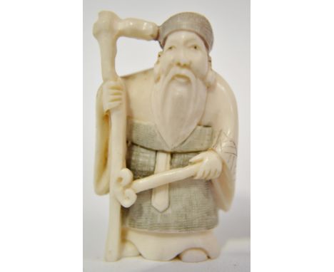 Japanese ivory Netsuke, carved as a sage holding a staff and sceptre, signed to the base, height 2"