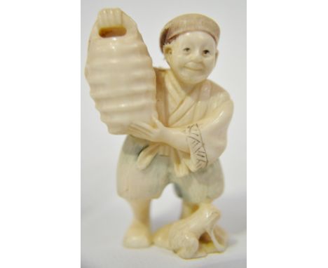 Japanese ivory Netsuke carved as a man holding a bucket a toad at his feet, signed to the base, height 2"