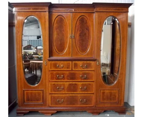 Edwardian figured mahogany and satin banded inverted breakfront wardrobe, the centre  with a pair of doors with oval panels a