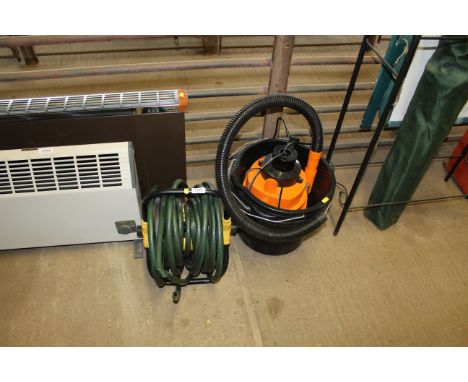 A garden hose on reel, a 12v electric hoover, three plastic buckets
