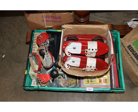 A box containing vintage moon boots; a pair of roller skates, various board games, puzzles fish knives and forks etc.