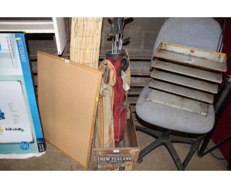 A wooden apple crate containing various vintage tools and a golf bag with some clubs 