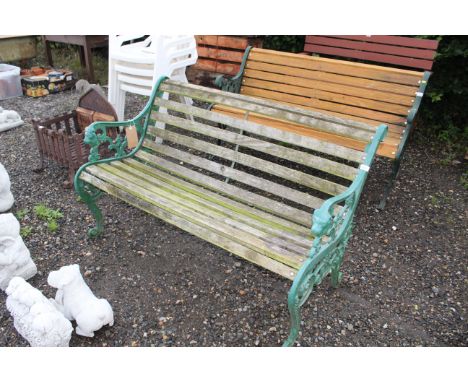 A cast iron and wooden slatted garden bench with lion head decoration 