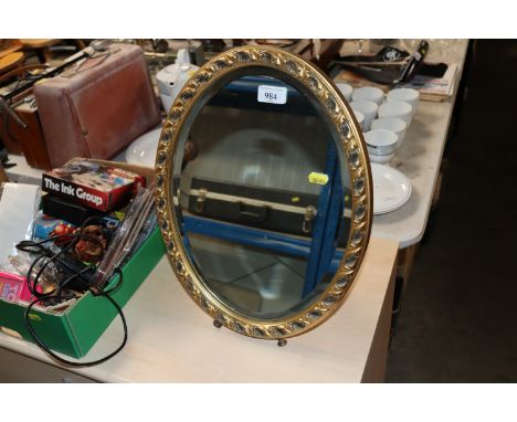 An oval gilt framed and bevel edged easel mirror