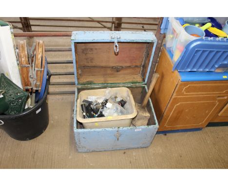 A painted wooden storage box with contents of various tools including mallets, scrapers, hammers and plastic tub of various p