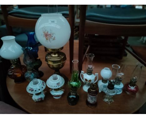 Collection of various oil lamps includes brass oil lamp with globe cover 