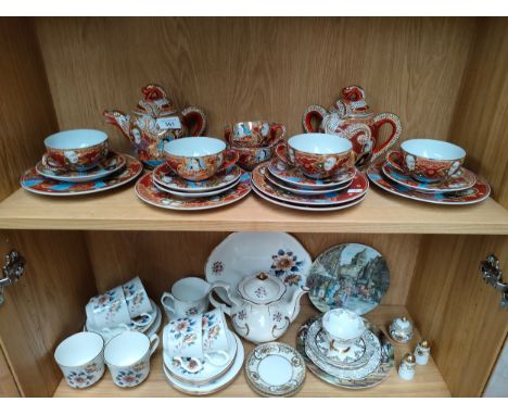 2 Shelves of tea wares to include oriental dragon pattern tea service, showing Geisha head sculpt to the inside of the cups. 