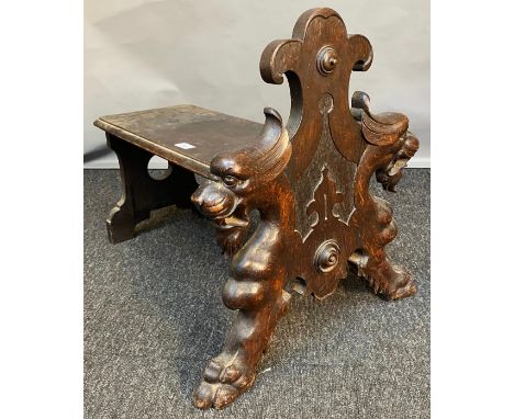 19th century small bench/ foot stool. Designed with carved front facing panel depicting lion style heads and paws. [51x62x41c
