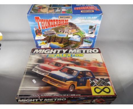 A boxed Matchbox Thunderbirds Tracy Island playset and a boxed Scalextric Mighty Metro racing set, both unchecked for complet