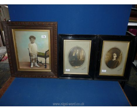 Two black and white portraits of young men in ebonised frames plus a coloured portrait of a young boy.