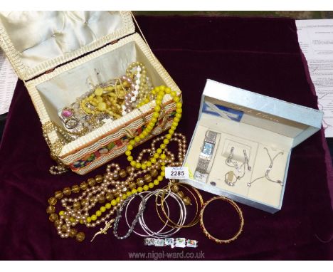 A quantity of costume jewellery including bangles, vintage plastic beads, coloured pearls and a boxed set watch, earrings, ri