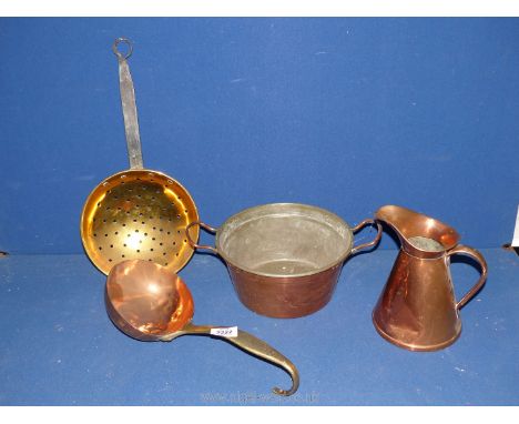 Four items including copper cooking pot, jug and ladle with brass handle and a brass skimmer.