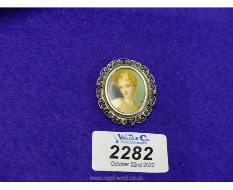 An 800 continental filigree framed miniature portrait brooch of a nude female.