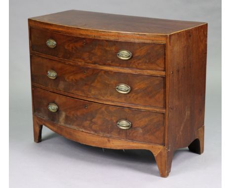 A Georgian mahogany bow-front chest fitted three long drawers with oval brass swing handles, on shaped bracket feet, 40¼” wid