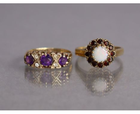 A 9ct gold ring set three amethysts with pairs of small white stones in between, size H/I, 2.2g; &amp; another set circular o