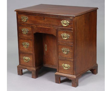 A George III style mahogany small kneehole desk with moulded edge to the rectangular top, fitted an arrangement of eight draw