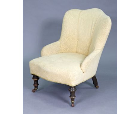 A Victorian nursing chair with shaped buttoned-back, upholstered ivory floral fabric, on turned front legs with ceramic casto