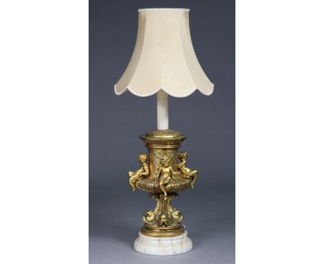 A reproduction gold-painted table lamp of classical urn form with cherubs &amp; dolphin supports, on circular marble base, &a