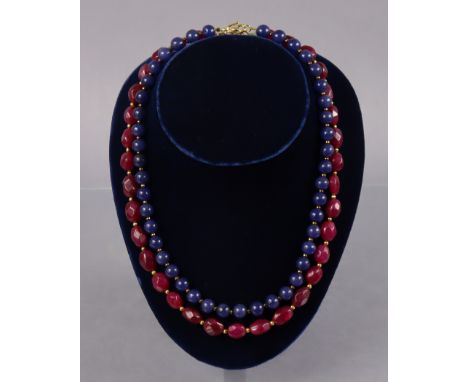 A necklace of opaque ruby oval facetted beads, 20½” long; &amp; another of spherical sapphire beads, 18½” long.