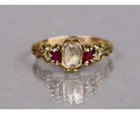 An antique gold ring set cushion-shaped old cut foil-backed diamond, a small ruby either side; size: %, weight: 3.3 gm.