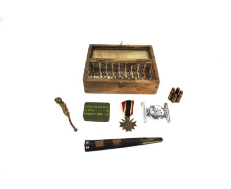 A box containing military related items including a German Merit medal with swords, a .455 revolver clip enabling the use of 