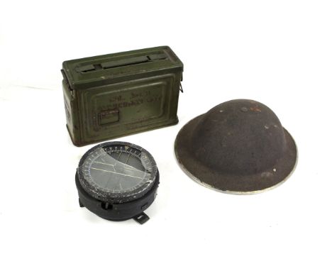 A British WWII helmet with a .30 U.S. M1 ammunition can, and a type 10 compass A/F