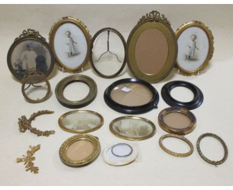A collection of seventeen circular and oval period portrait miniature frames, a mixture of plain wood and gilt, including a t