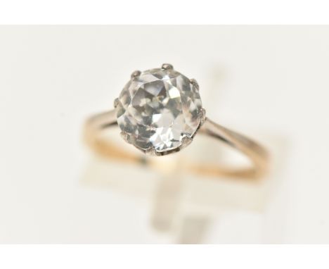 A YELLOW AND WHITE METAL GEM SET RING, set with a circular cut colourless paste, claw set in a white metal mount, leading ont