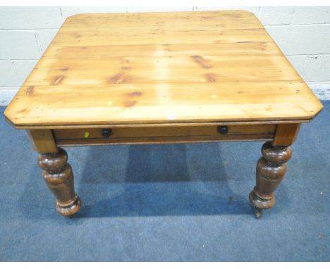 A 19TH CENTURY PINE FARMHOUSE TABLE, with canted corners, a single frieze drawer, raised on cylindrical tapered legs, with ce