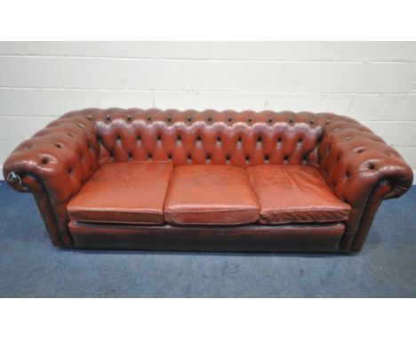 AN OXBLOOD LEATHER CHESTERFIELD THREE SEATER SOFA, with buttoned back and armrests, length 230cm x depth 93cm x height 76cm (