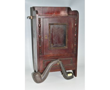 A MAHOGANY SMOKERS CABINET, wall-mountable or free standing, the glazed door opens to reveal two pipe racks with spaces for s