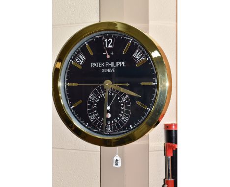 A  'DISPLAY CLOCK' printed 'Patek Philippe', with a dark blue printed background with printed day, date and month details, wi