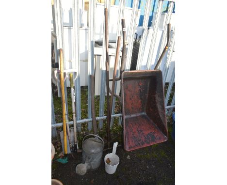 A SELECTION OF GARDEN TOOLS, to include a metal wheelbarrow, seven various garden hand tools, a galvanised watering can, etc 