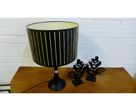 A contemporary table lamp and shade, together with a pair of black metal cockerel candlestick holders (3) 