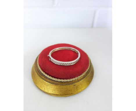 A child's white metal and paste set bangle 