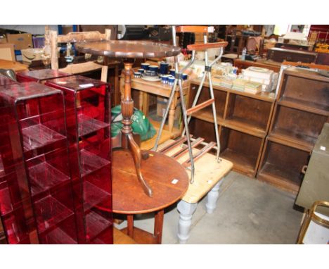 A circular topped table and one other raised on tripod base