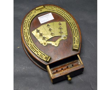 An oak and brass horseshoe shaped cribbage board