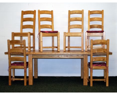 A contemporary light oak extending dining table, with six ladder-back chairs