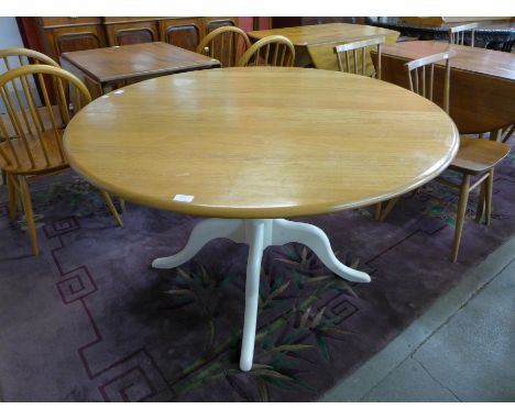 An Ercol Blonde circular table, with painted base