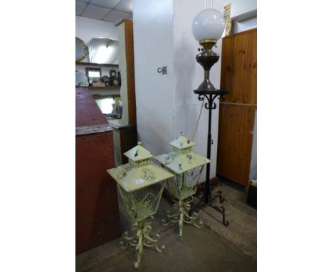 A pair of French style wrought iron lanterns, a brass lamp and jardiniere stand