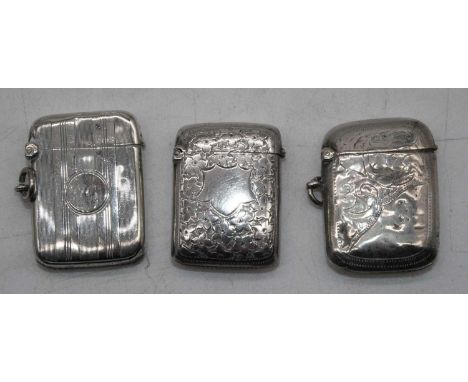 A late Victorian silver vesta, of hinged rectangular form, having foliate engraved decoration and vacant cartouche; together 