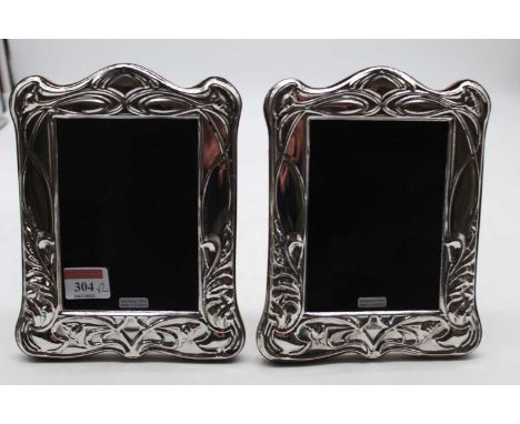 A pair of modern silver clad easel photograph frames, in the Art Nouveau style with raised sinuous floral decoration, 20 x 16