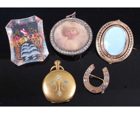An early 20th century perspex brooch, with cased decoration; together with a yellow metal and paste set horseshoe brooch; por