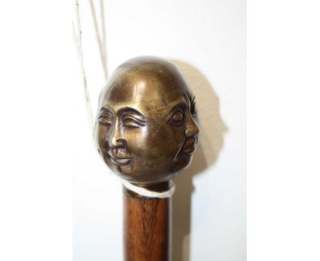 A modern walking stick, the handle in the form of a four-faced Buddha, 91cm 
