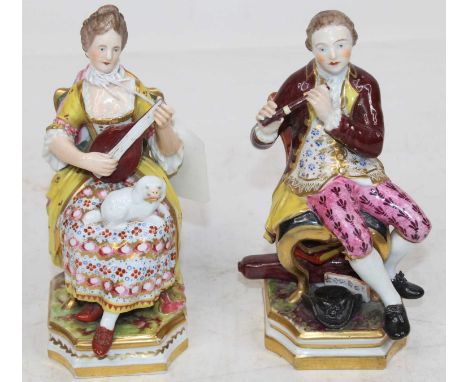 A pair of Derby style soft-paste porcelain figures of musicians, each in seated pose, he in red overcoat and pink breeches pl