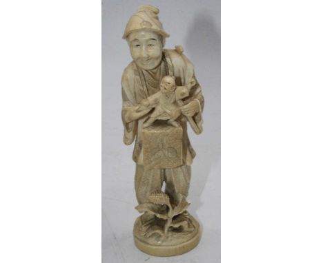 A Japanese Meiji period okimono, carved as a peasant man with puppet before him, signed verso, h.19cm; together with one othe