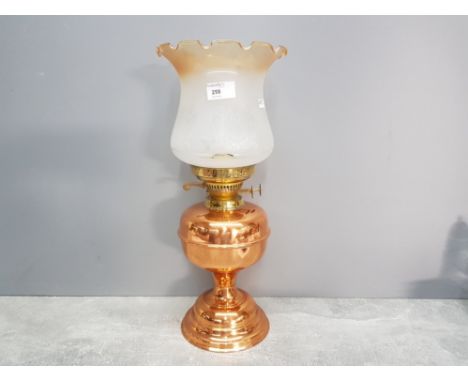 A copper oil lamp with glass shade 44.5cm high.