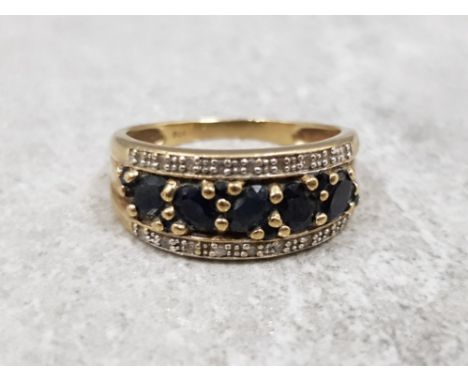 Ladies 9ct yellow gold sapphire + diamond ring, featuring 5 oval black sapphires set in the centre with 9 diamonds set on eac