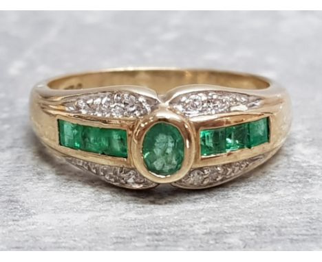 Ladies 9ct yellow gold green and white stone ring, comprising of round green stone in the centre with 3 princess cut green st